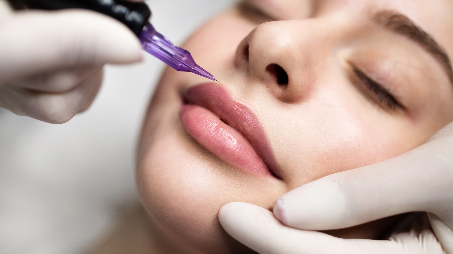 A woman getting a permanent tattoo on her face