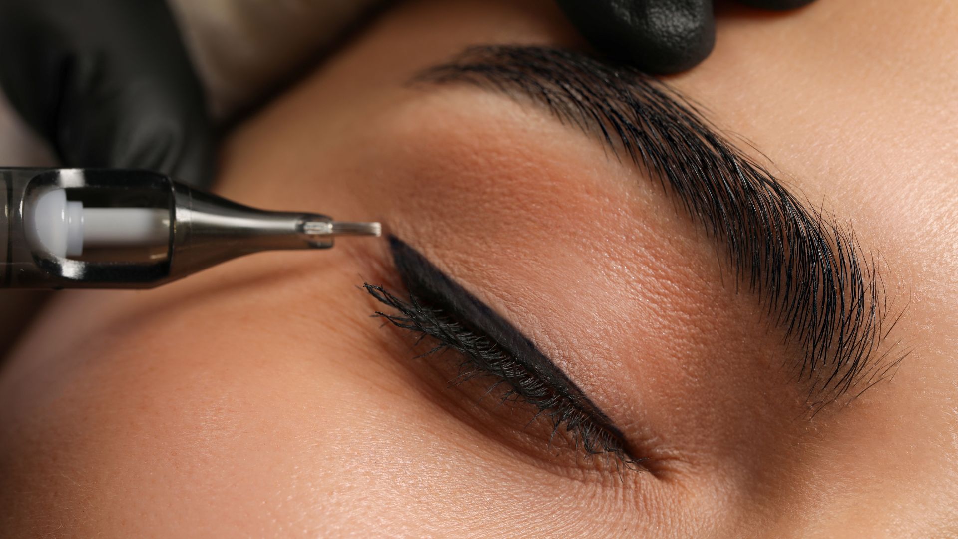 A woman getting her eyebrows done with a hair dryer